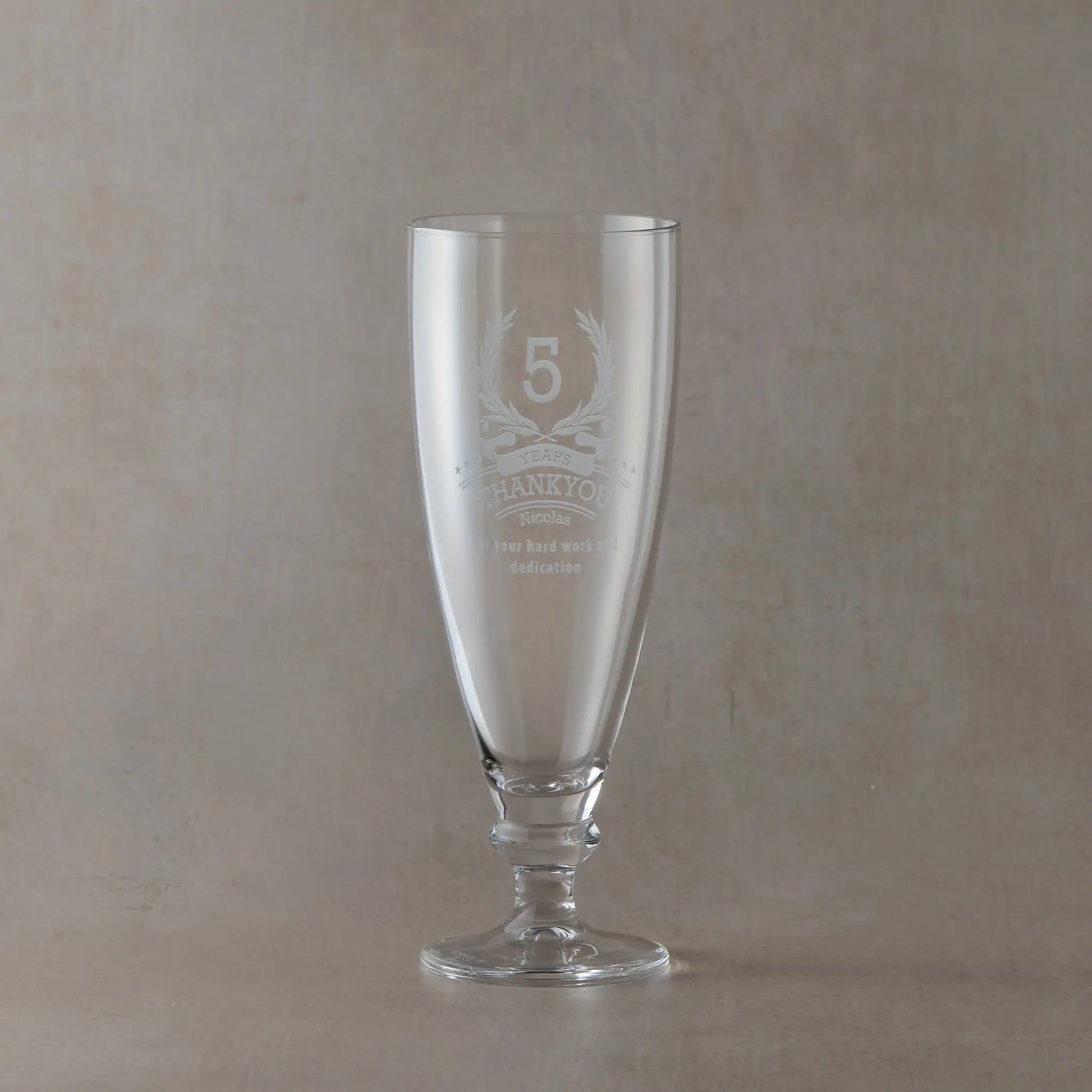 Clear stemmed beer glass engraved with a laurel wreath, stars, and a thank you message with the recipient’s name.