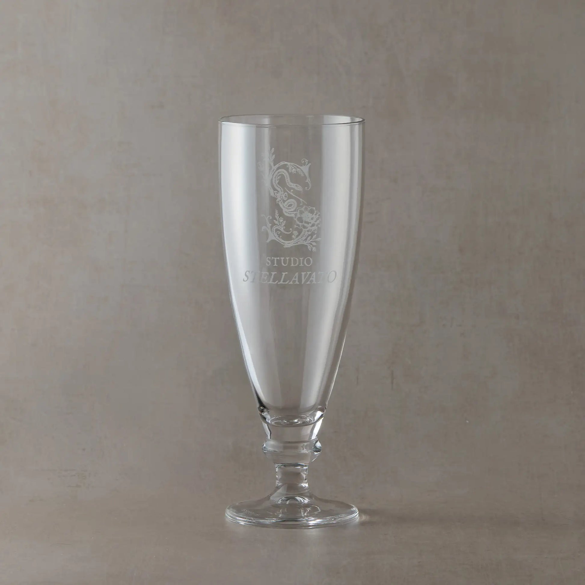 Custom corporate tapered stemmed beer glass engraved with business logo, shown on a neutral background