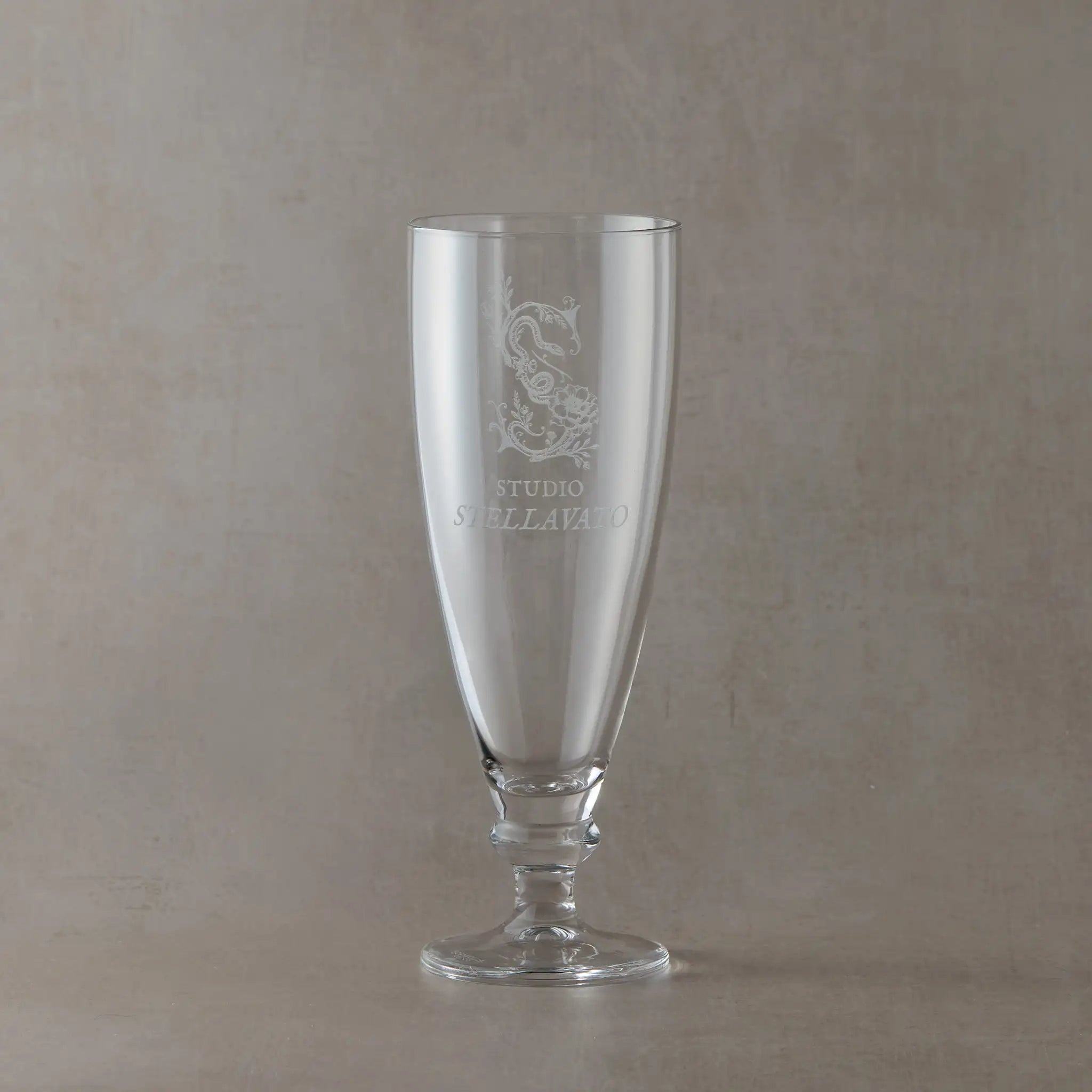 Custom corporate tapered stemmed beer glass engraved with business logo, shown on a neutral background