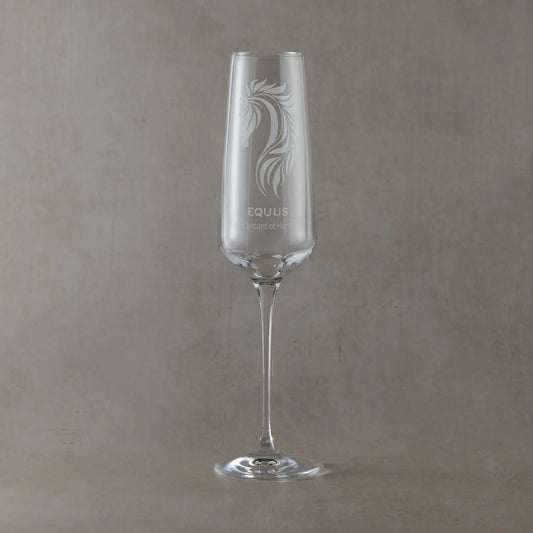 Champagne flute engraved with custom corporate logo and text design on a beige background