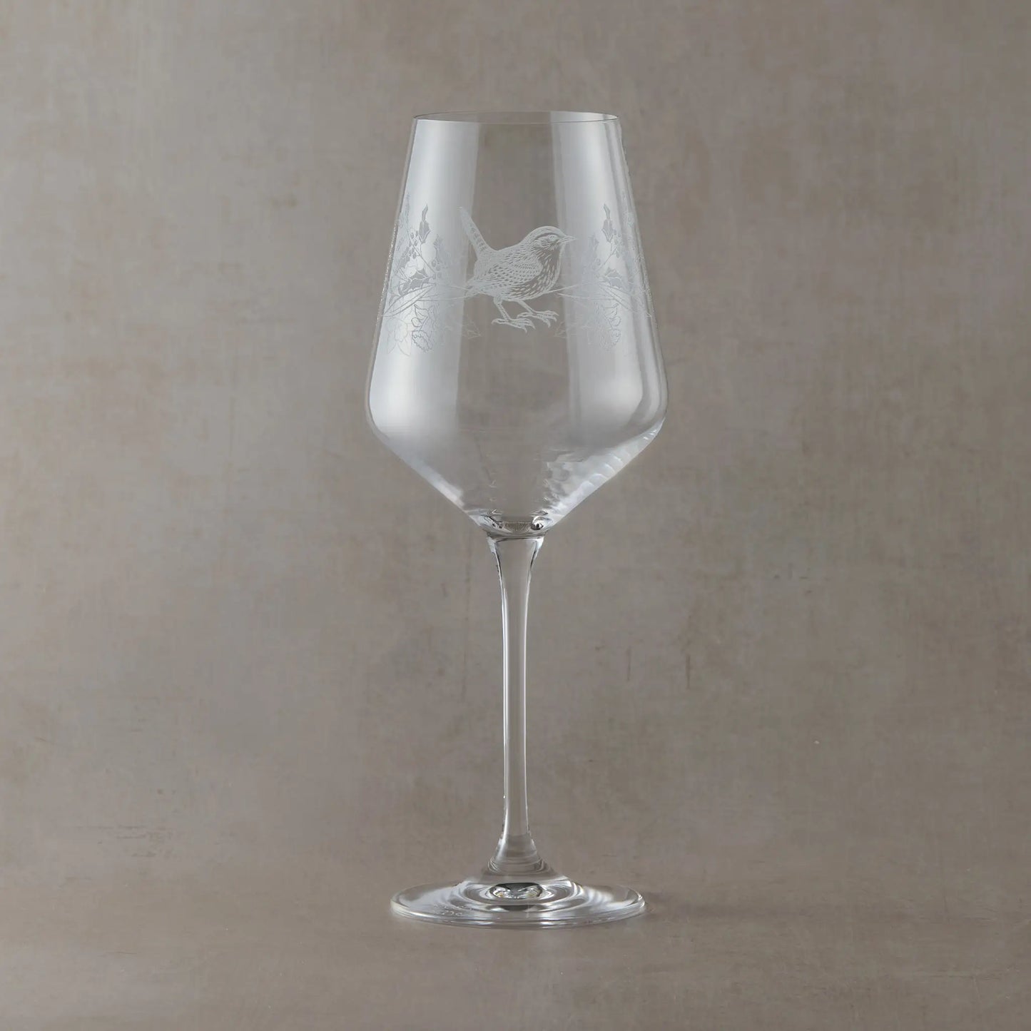 Engraved wine glass featuring December birth flowers with a wren shown on a beige backround