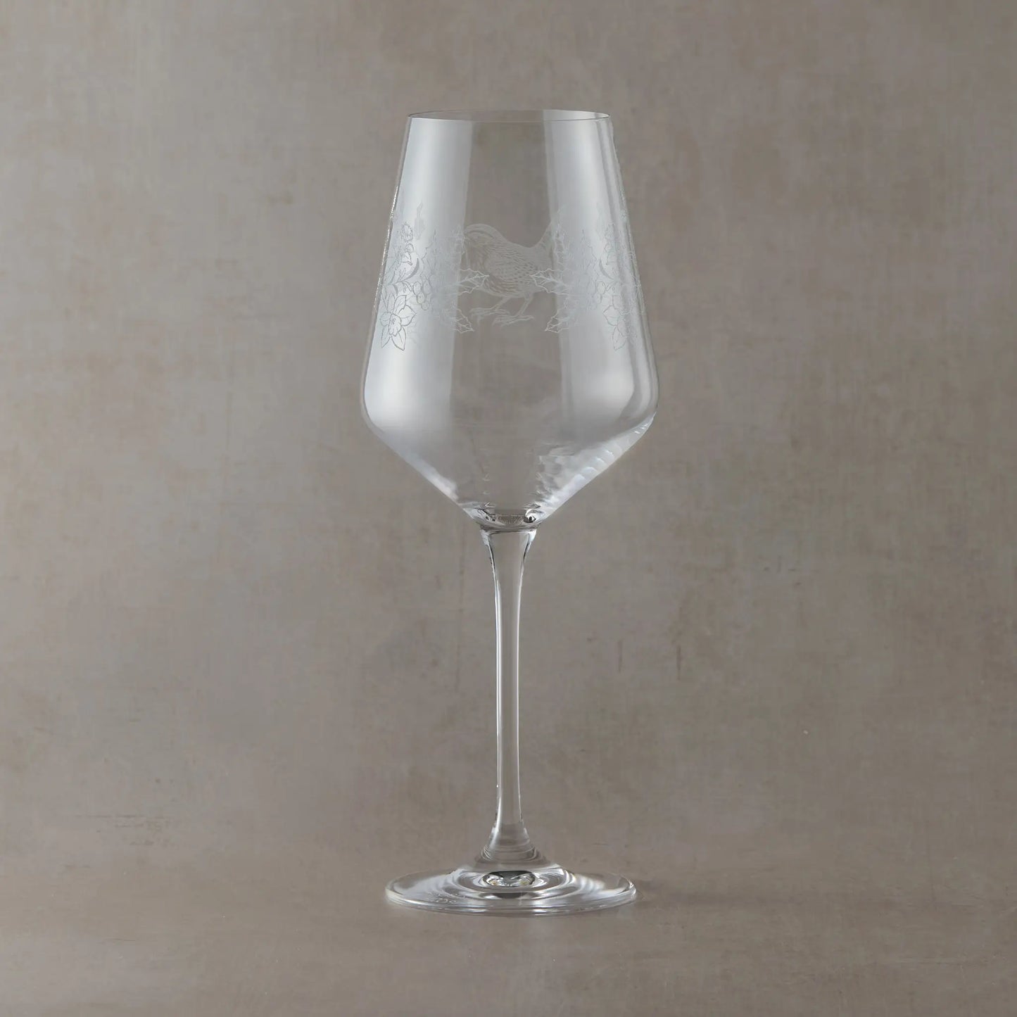 Engraved wine glass featuring December birth flowers holly and paperwhites with a wren in a wraparound design