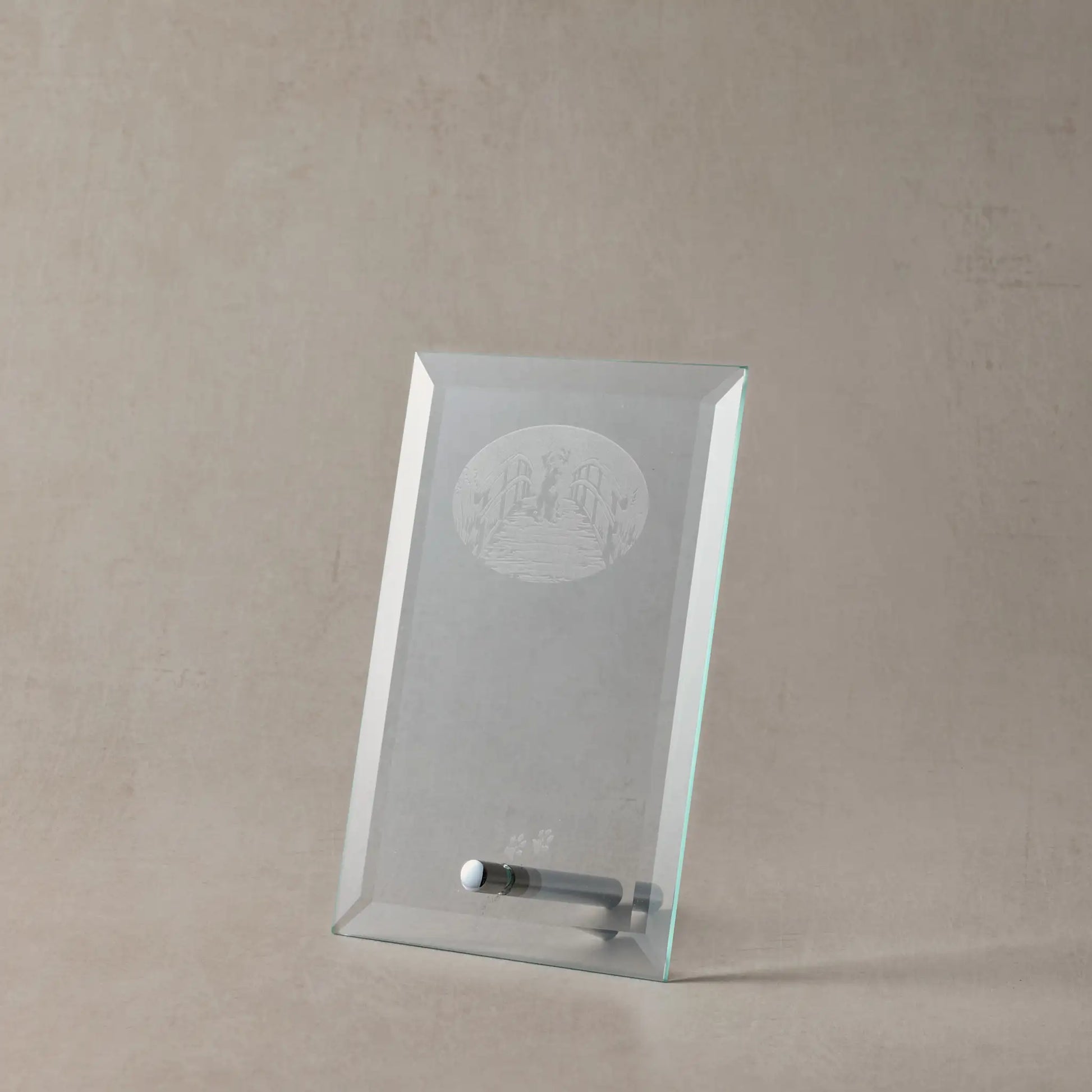 Clear glass display case with engraved dog design on a beige background