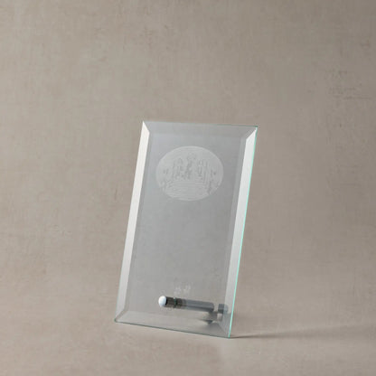 Clear glass display case with engraved dog design on a beige background