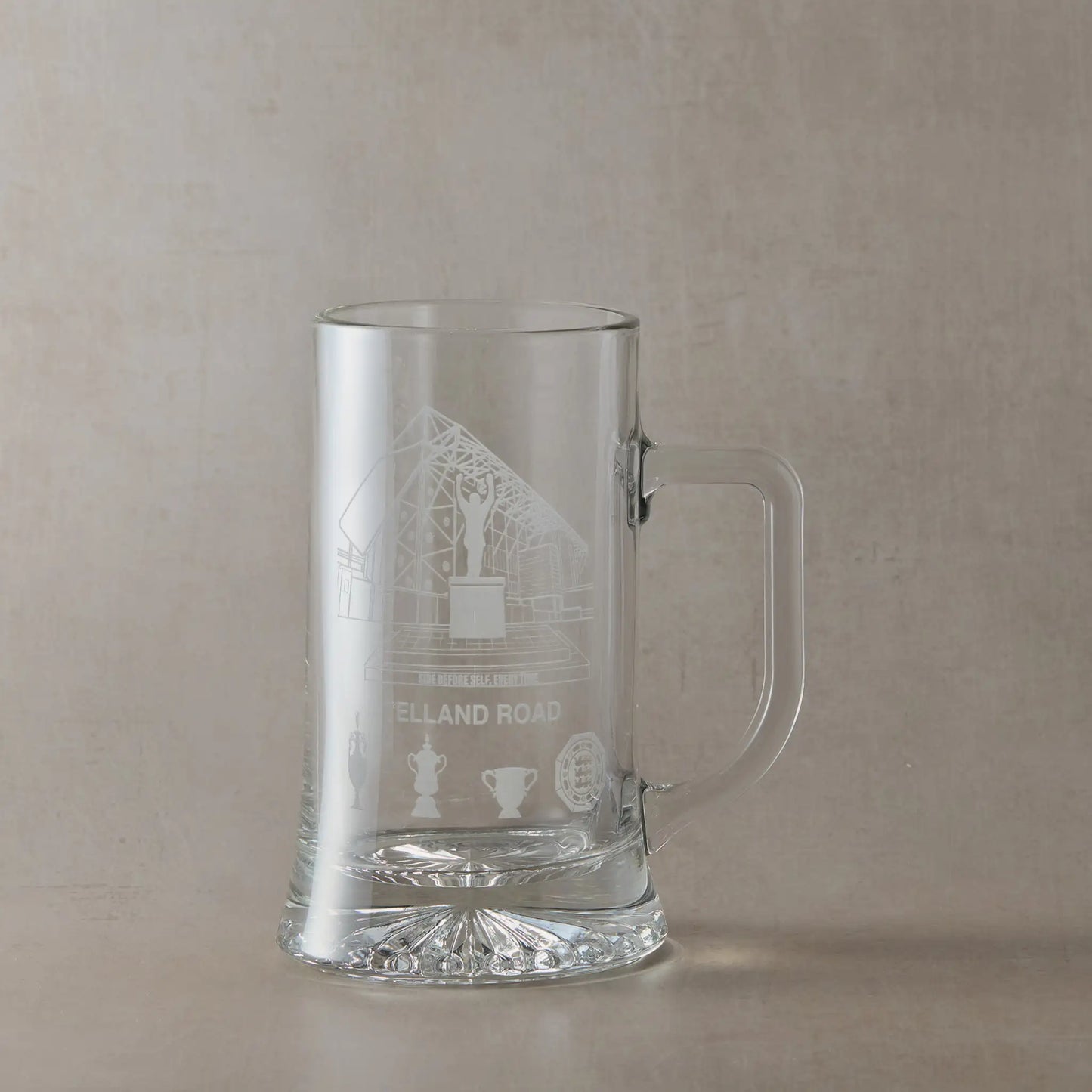 Clear glass tankard engraved with Elland Road stadium, photographed on a white background.
