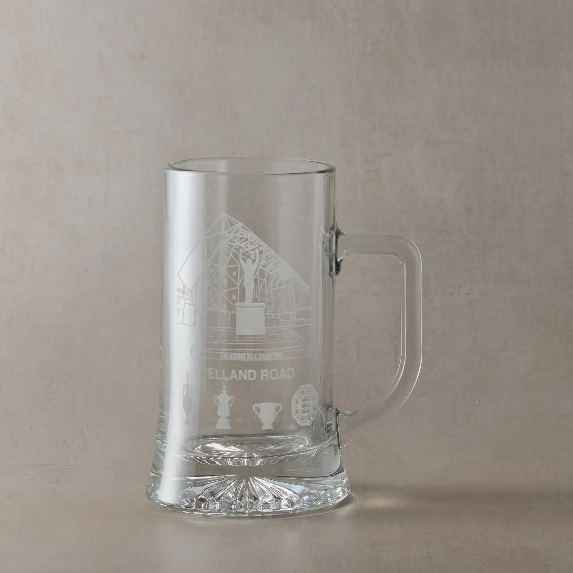 Clear glass tankard engraved with Elland Road stadium, photographed on a white background.