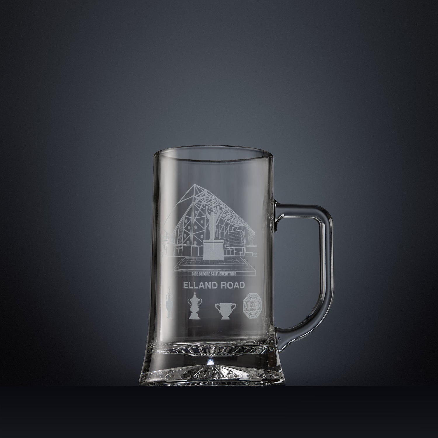 Engraved tankard featuring line-art architectural interpretation of Elland Road with trophy silhouettes beneath.