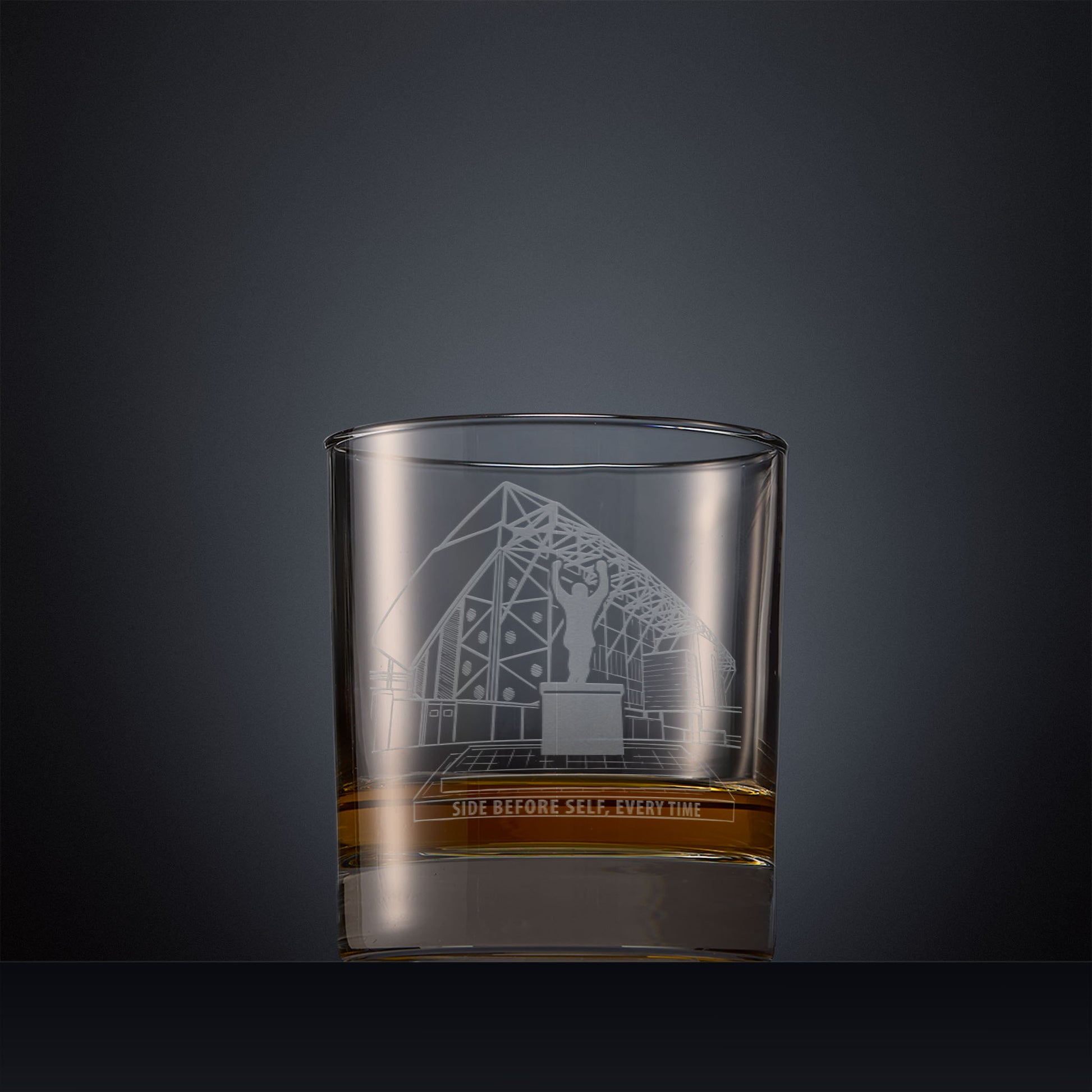 Engraved whisky glass featuring a line-art illustration of Elland Road stadium, shown on a dark background.