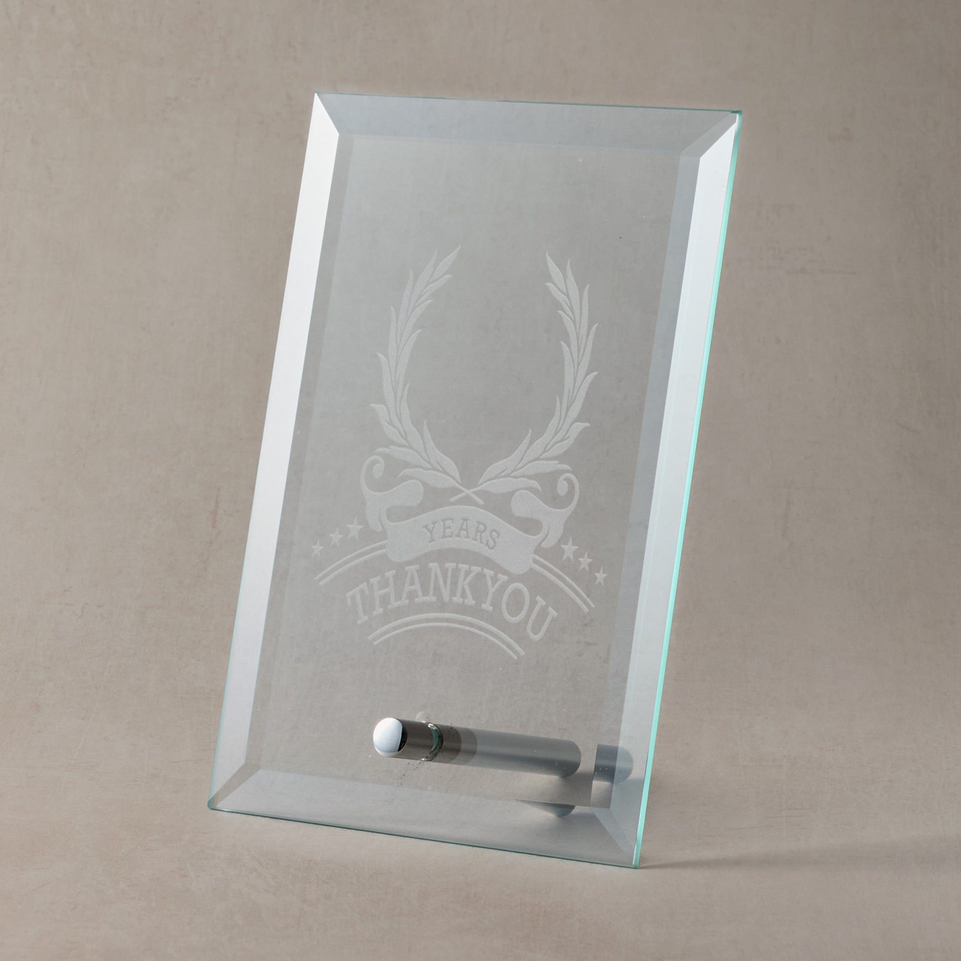 Glass plaque with engraved laurel wreath and thankyou design and text on a beige background
