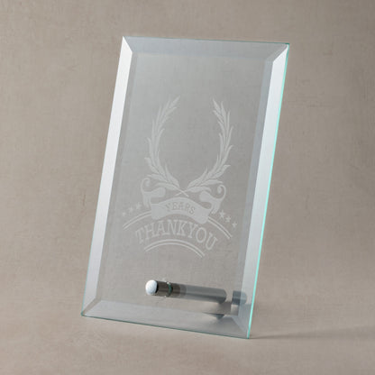 Glass plaque with engraved laurel wreath and thankyou design and text on a beige background