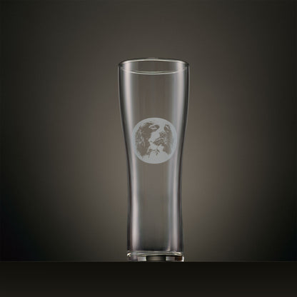 Engraved pint glass featuring an English Springer Spaniel portrait set within a circular design, photographed on a dark studio background