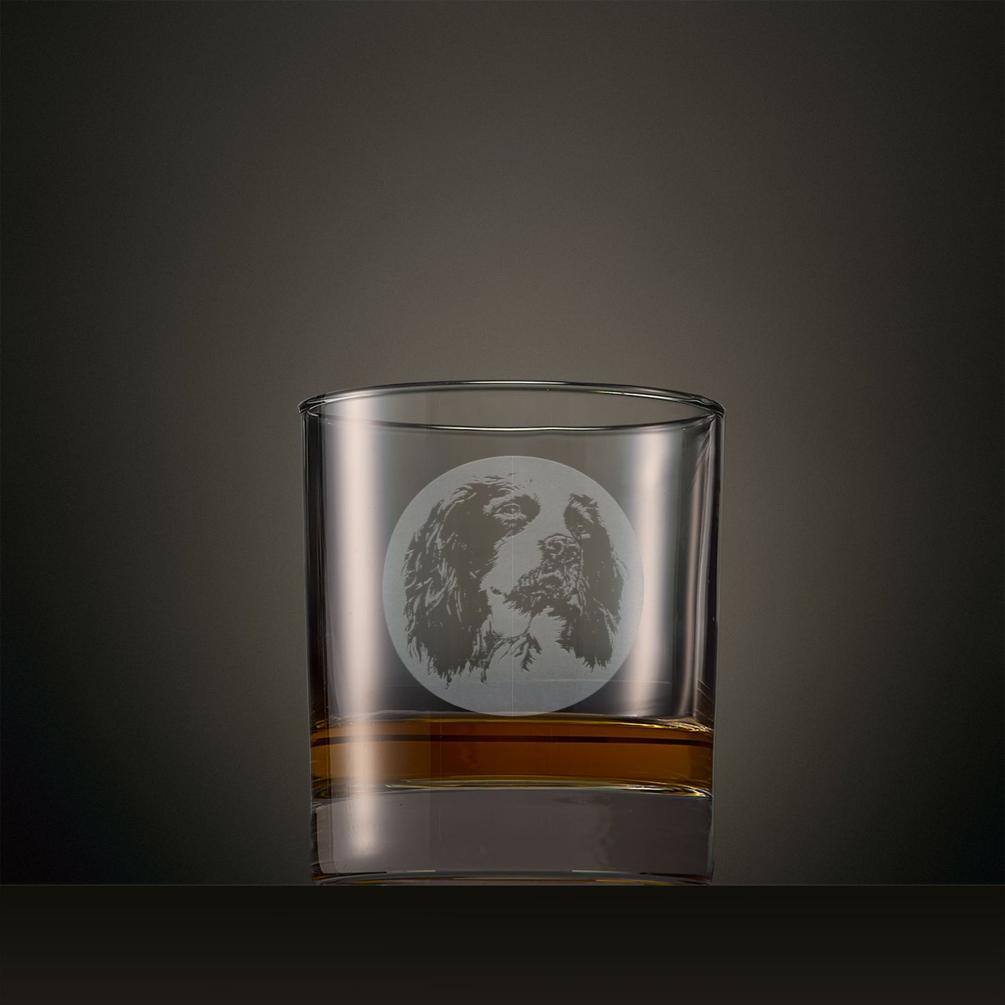 Engraved whisky glass featuring a Springer Spaniel portrait set within a circular design, photographed on a studio background