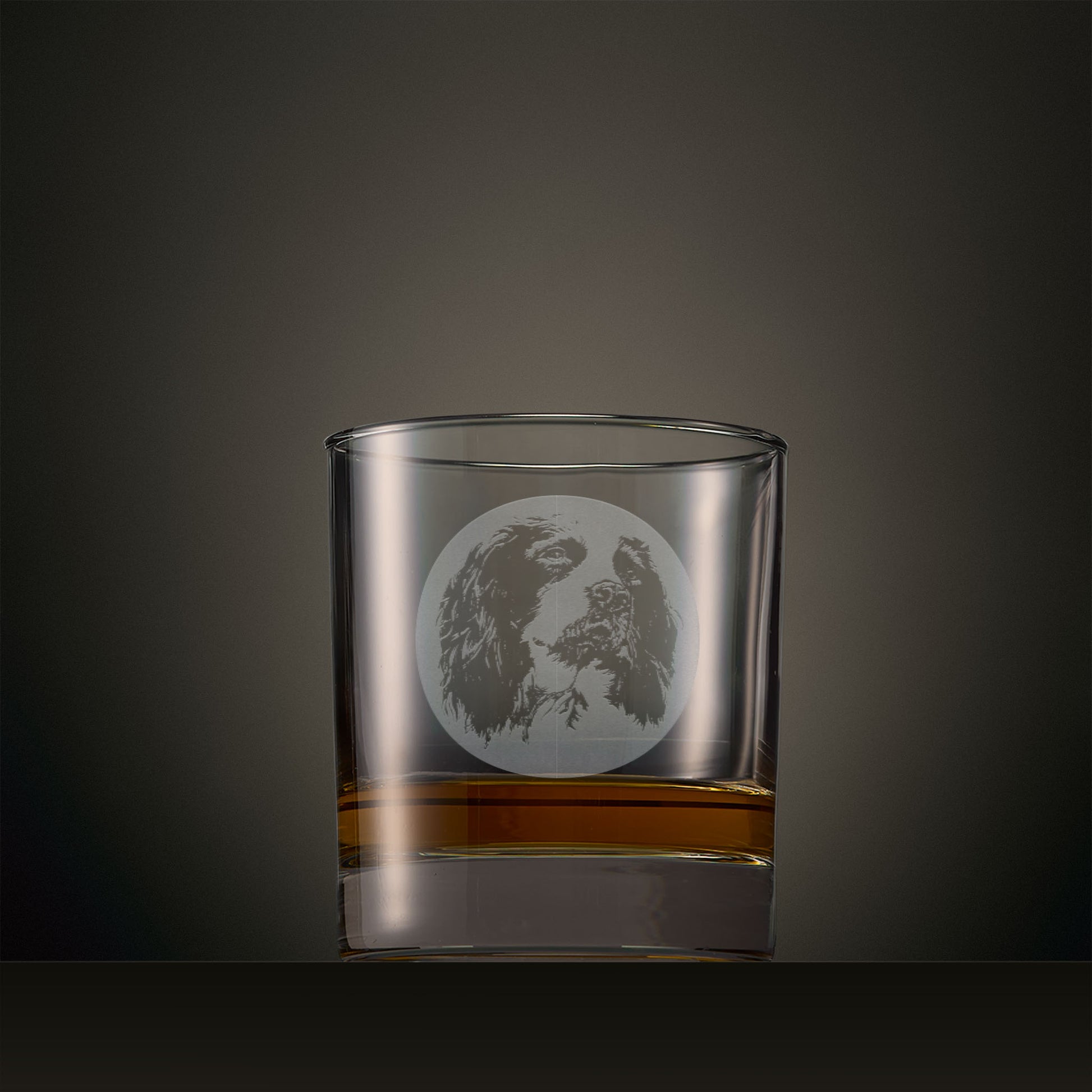 Engraved whisky glass featuring a Springer Spaniel portrait set within a circular design, photographed on a studio background