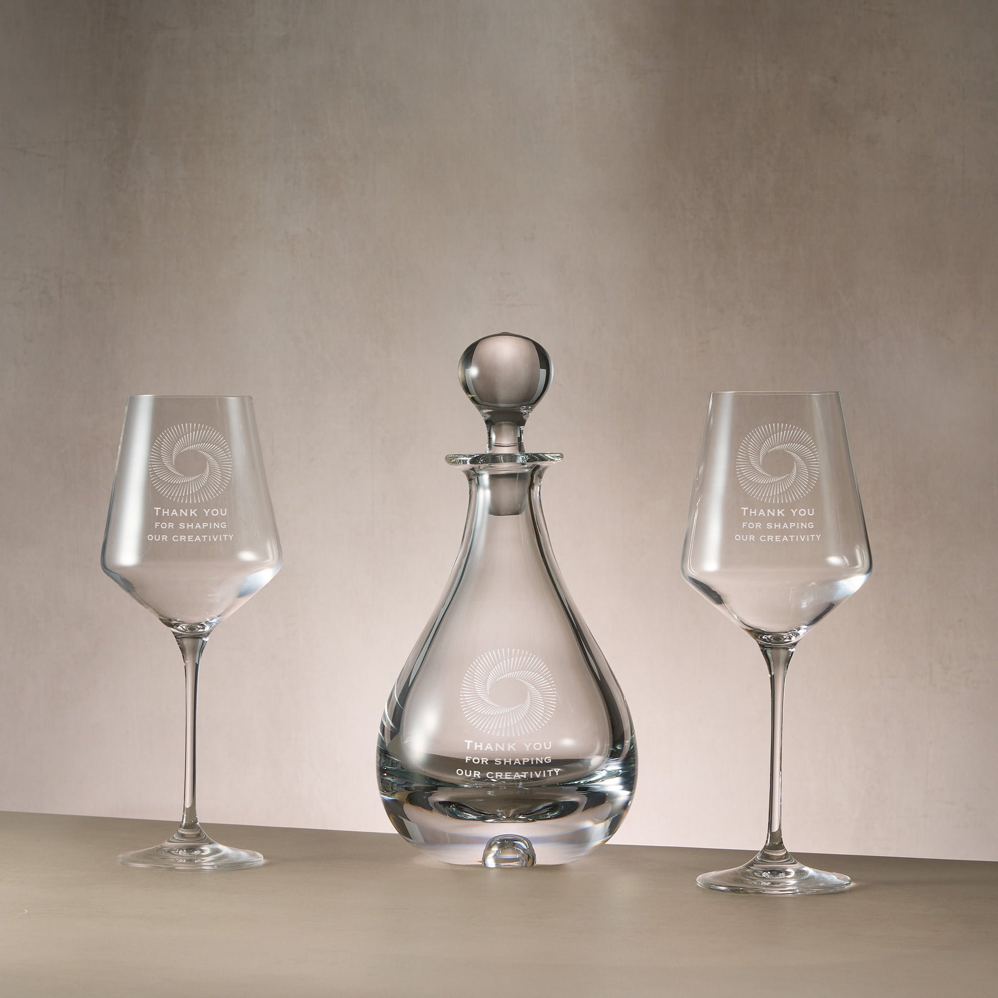 Engraved wine decanter and matching pair of wine glasses featuring bespoke corporate logo engraving.