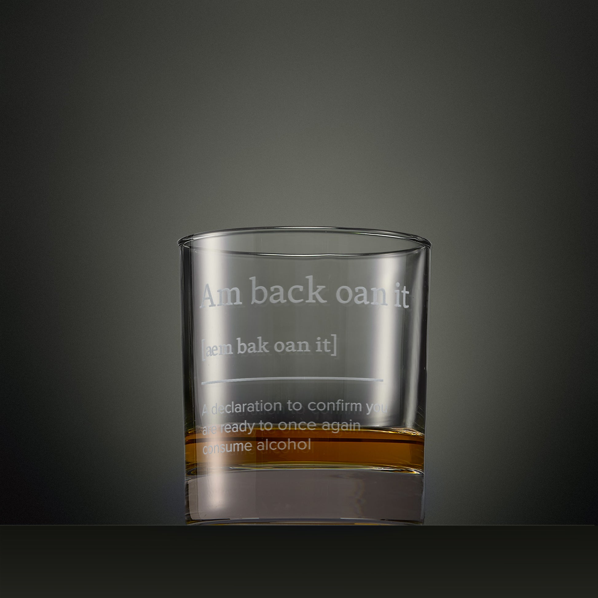 Engraved whisky glass featuring a typography design with the words 'Am Back Oan It' and explanatory text