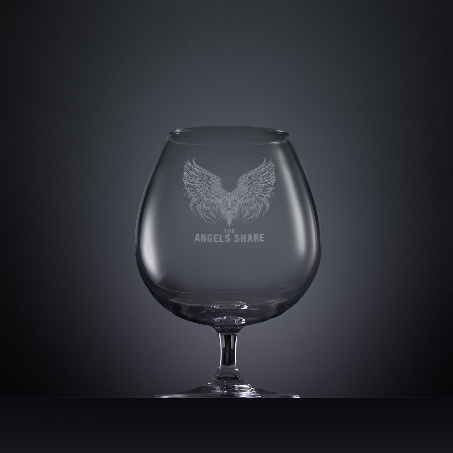 Engraved brandy glass with an  illustration of feathered wings and The Angels Share text