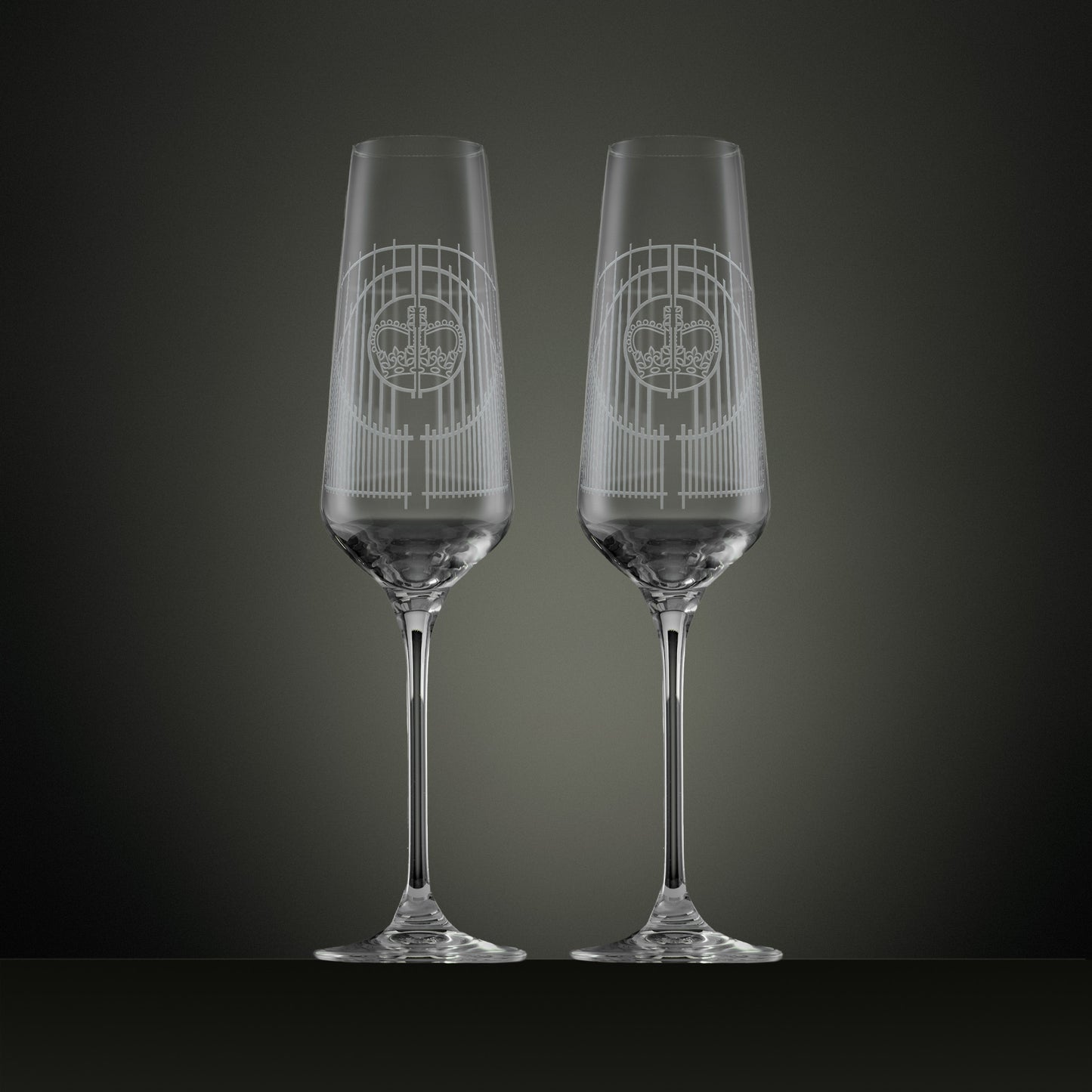 Two engraved champagne flutes with an illustration of the Ascot gates ironwork