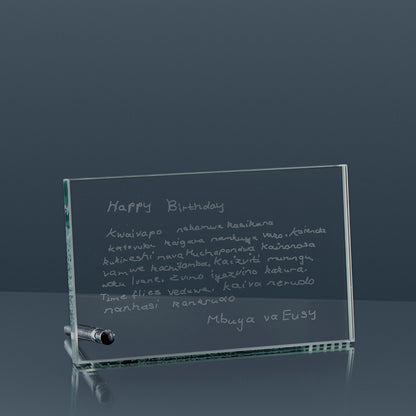 Jade glass plaque with engraved birthday message on a reflective surfacee