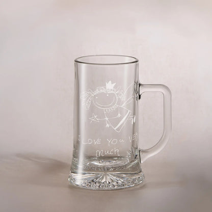 Clear glass tankard with engraved childs drawing and text on a light background