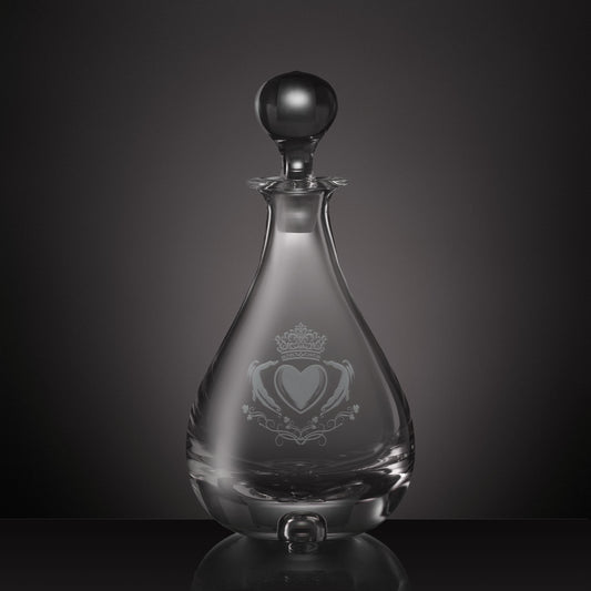 Engraved glass wine decanter with a rounded teardrop-shaped body, a matching glass stopper, and an etched Claddagh heart and crown design