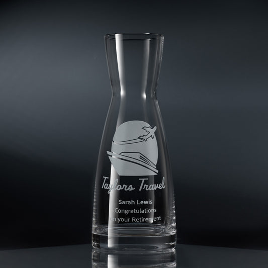 A clear glass carafe engraved with a corporate logo and personalised message