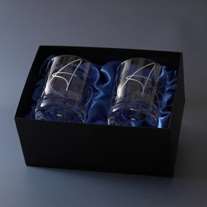Two engraved whisky glasses with a monogram in a black box lined with blue satin