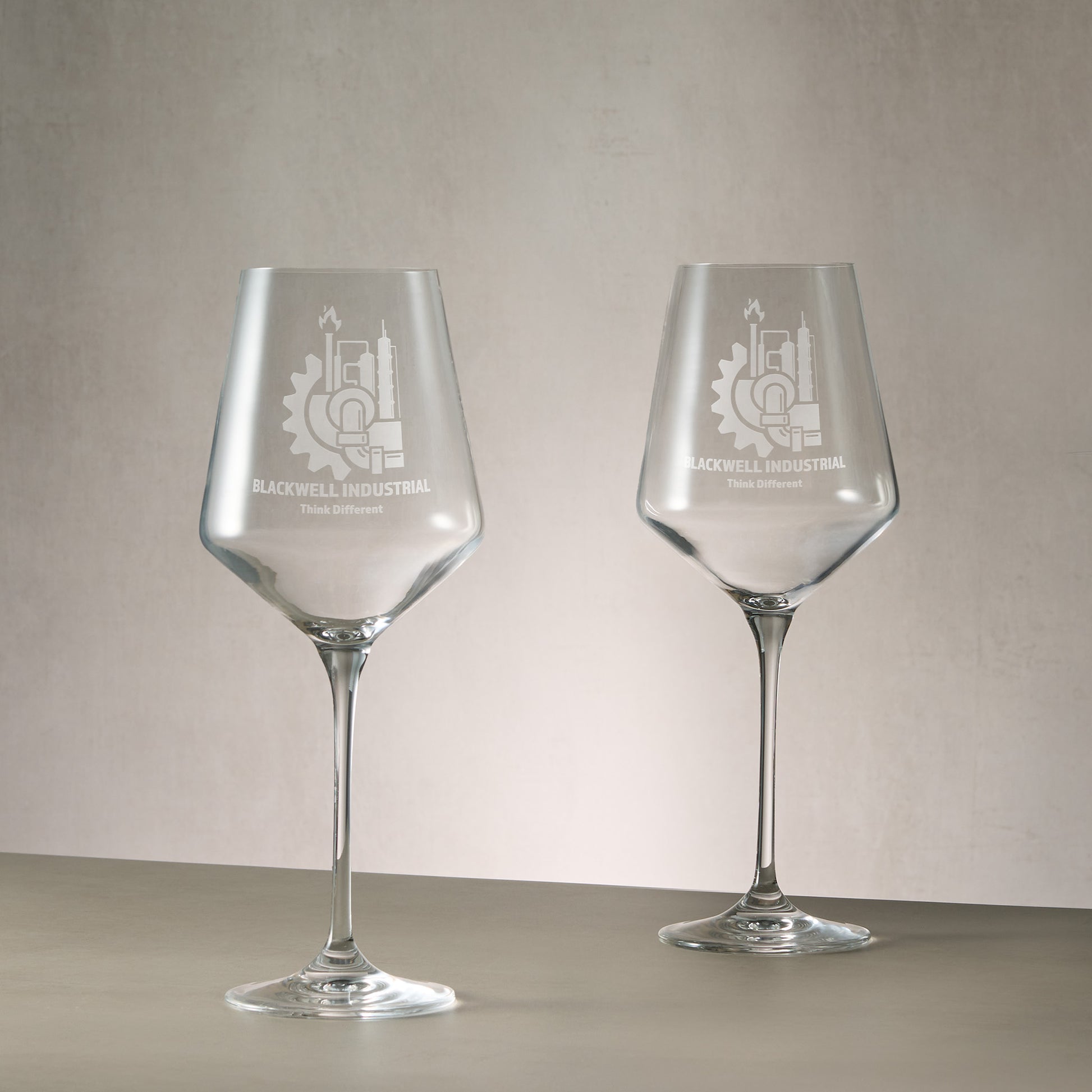 Pair of bespoke engraved wine glasses featuring a  corporate logo and inscription