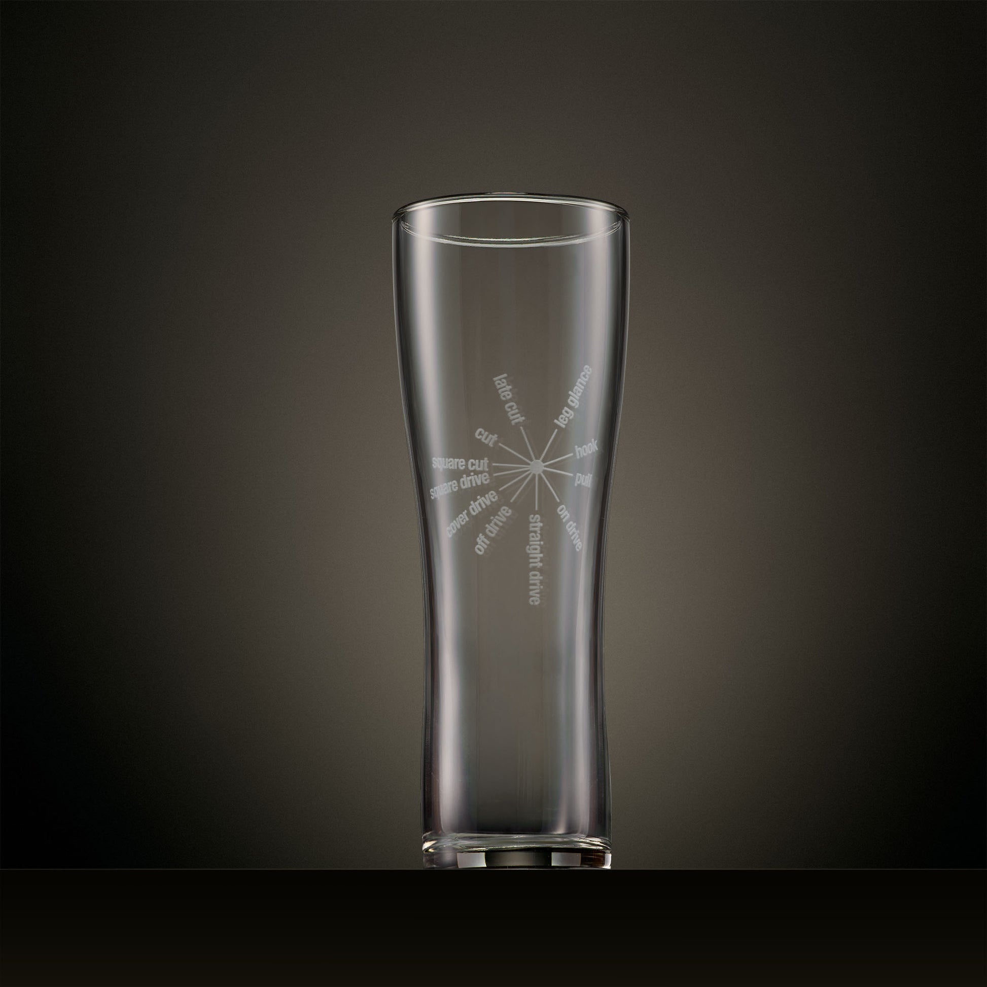 Engraved pint glass featuring a radial typography design of classic cricket batting strokes.