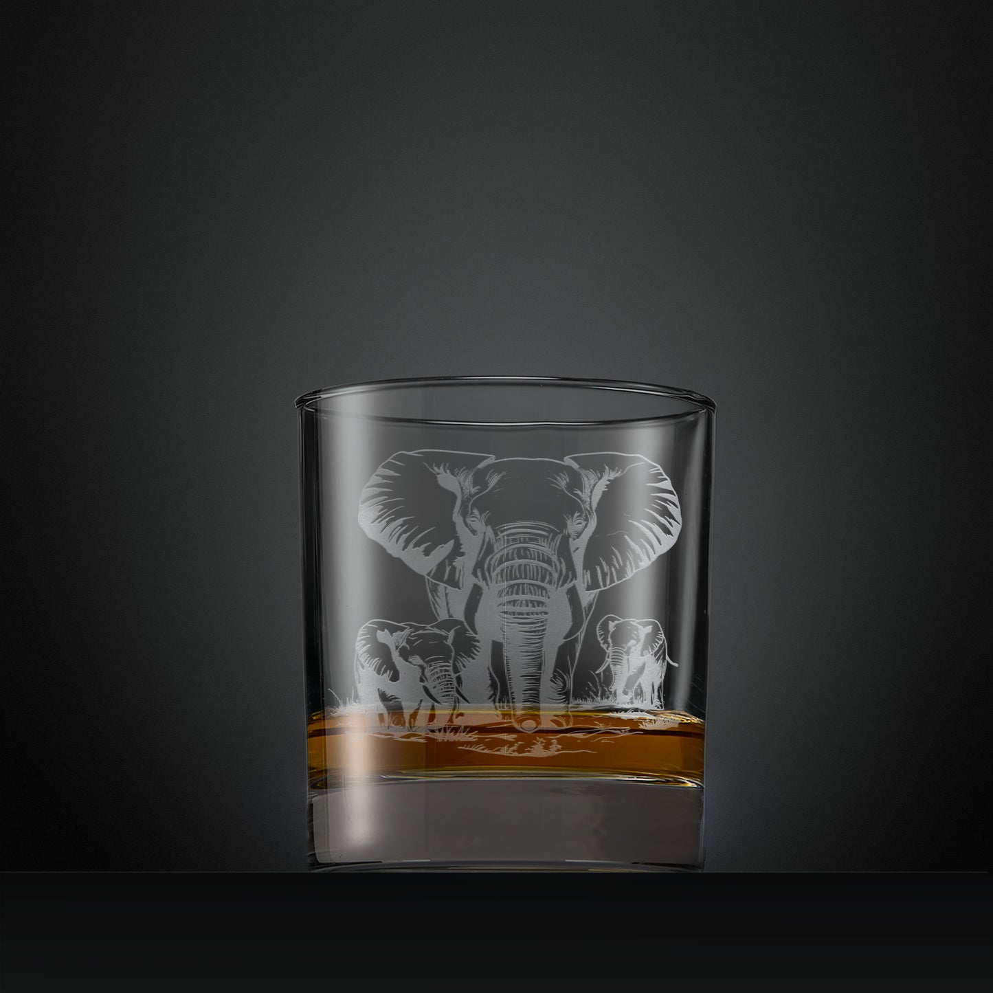 Engraved whisky glass featuring a mother elephant with two calves