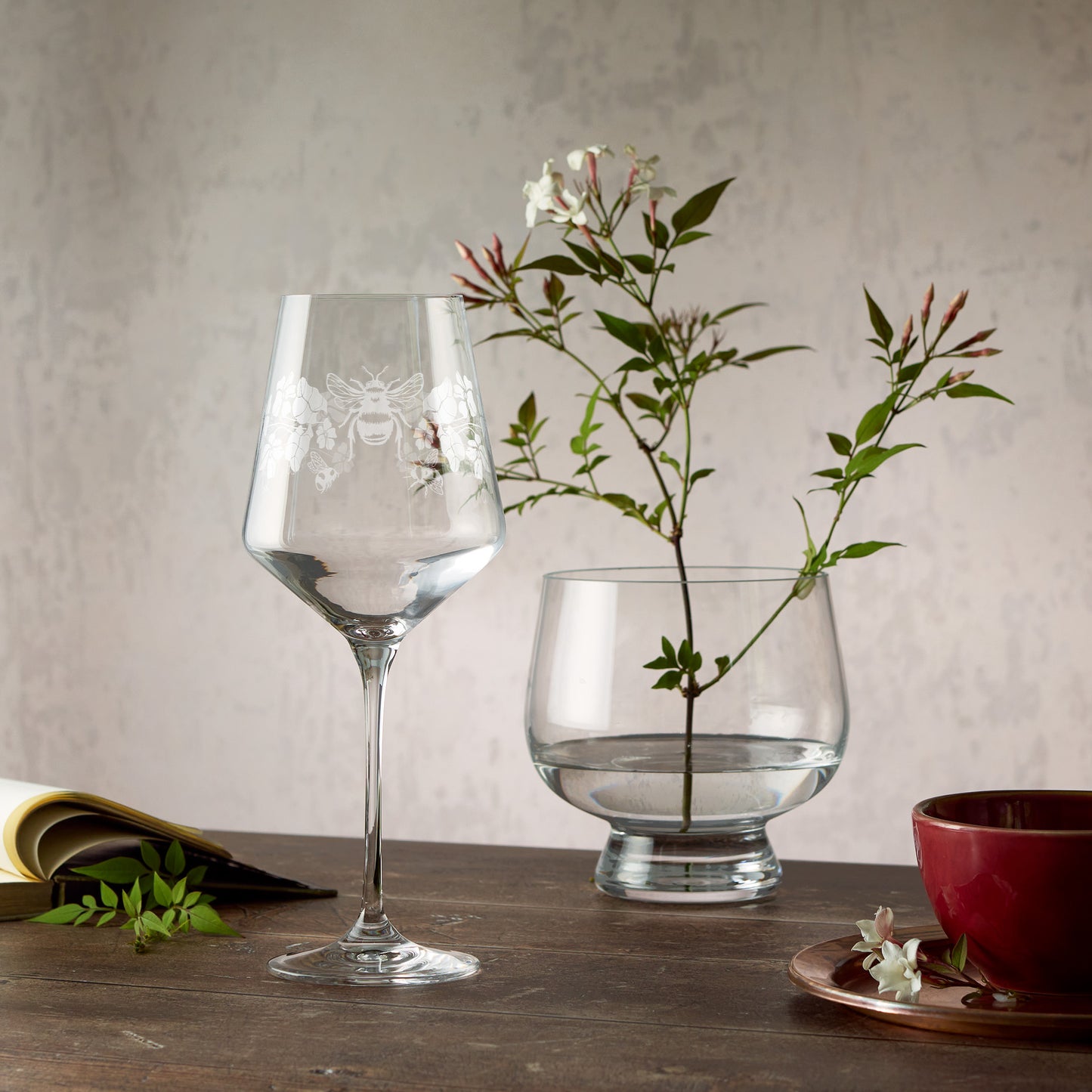 Engraved wine glass featuring primroses, violets and bees in a wraparound composition