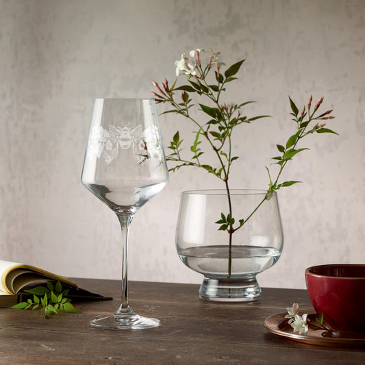 Engraved wine glass featuring primroses, violets and bees in a wraparound composition