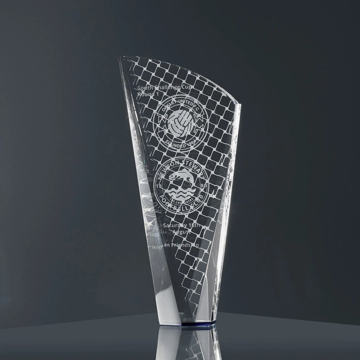 A modern optical crystal glass award engraved with football-themed graphics, team logos and personalised text