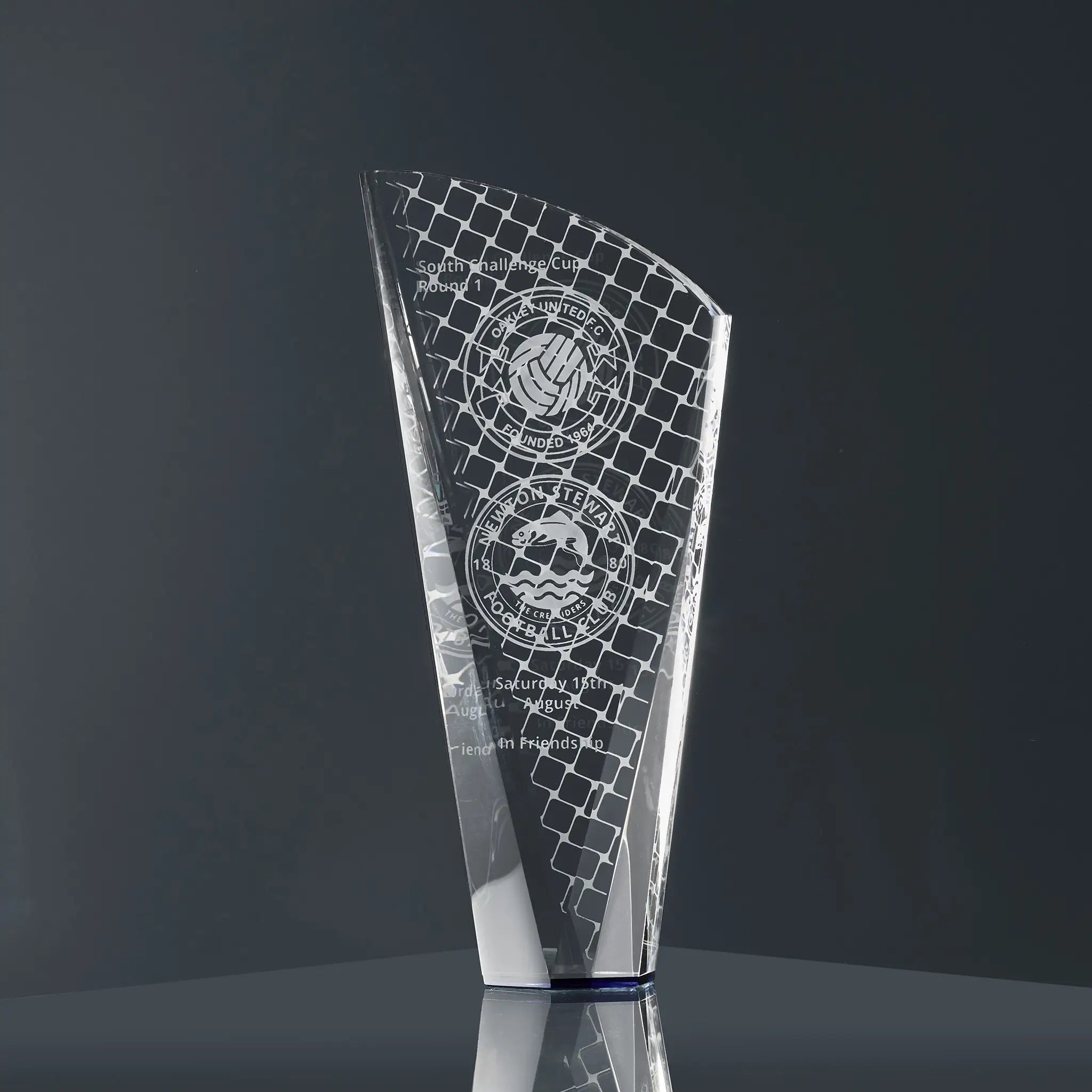 A modern optical crystal glass award engraved with football-themed graphics, team logos and personalised text
