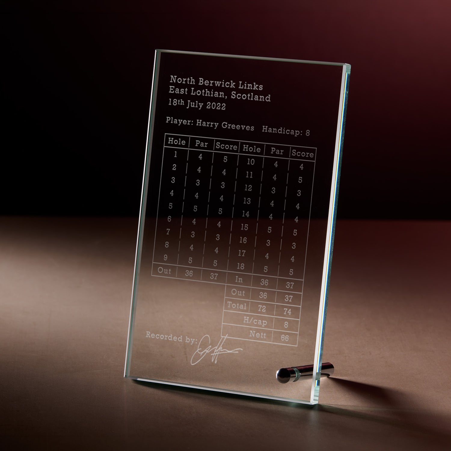 A personalised clear glass golf scorecard plaque engraved with payers, name, handicap par, score and signature