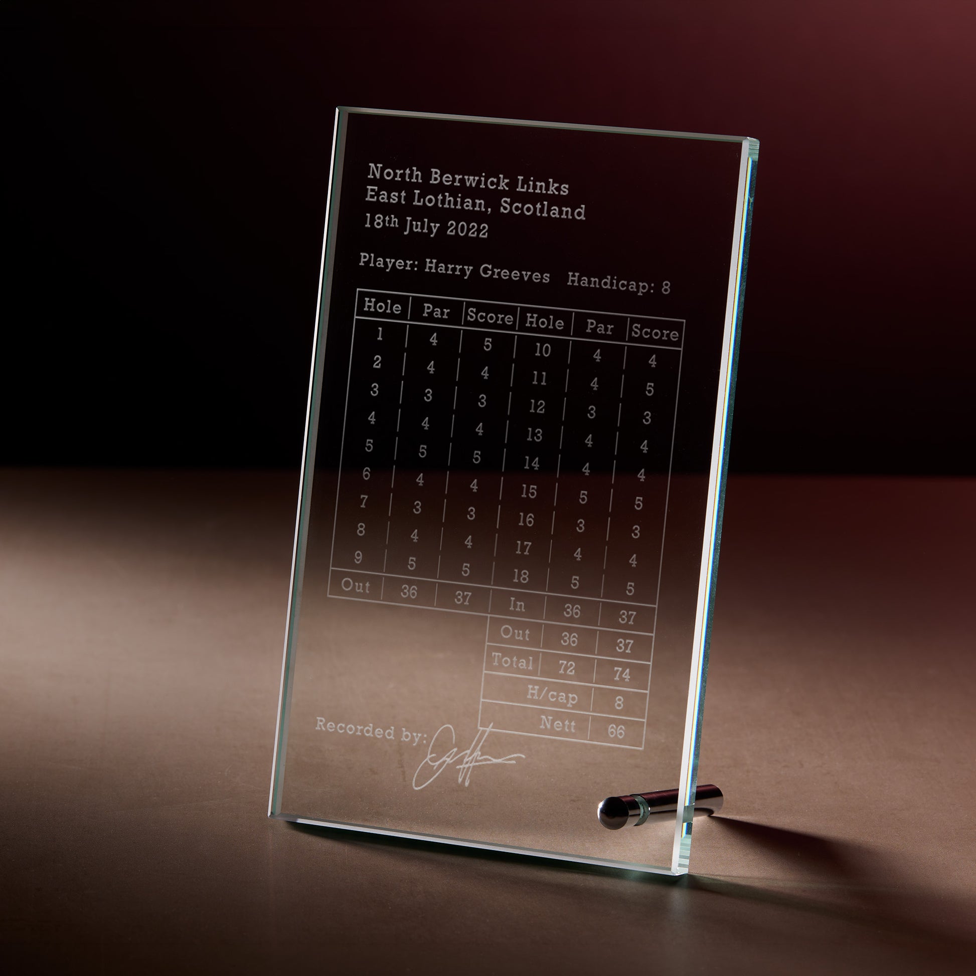A personalised clear glass golf scorecard plaque engraved with payers, name, handicap par, score and signature