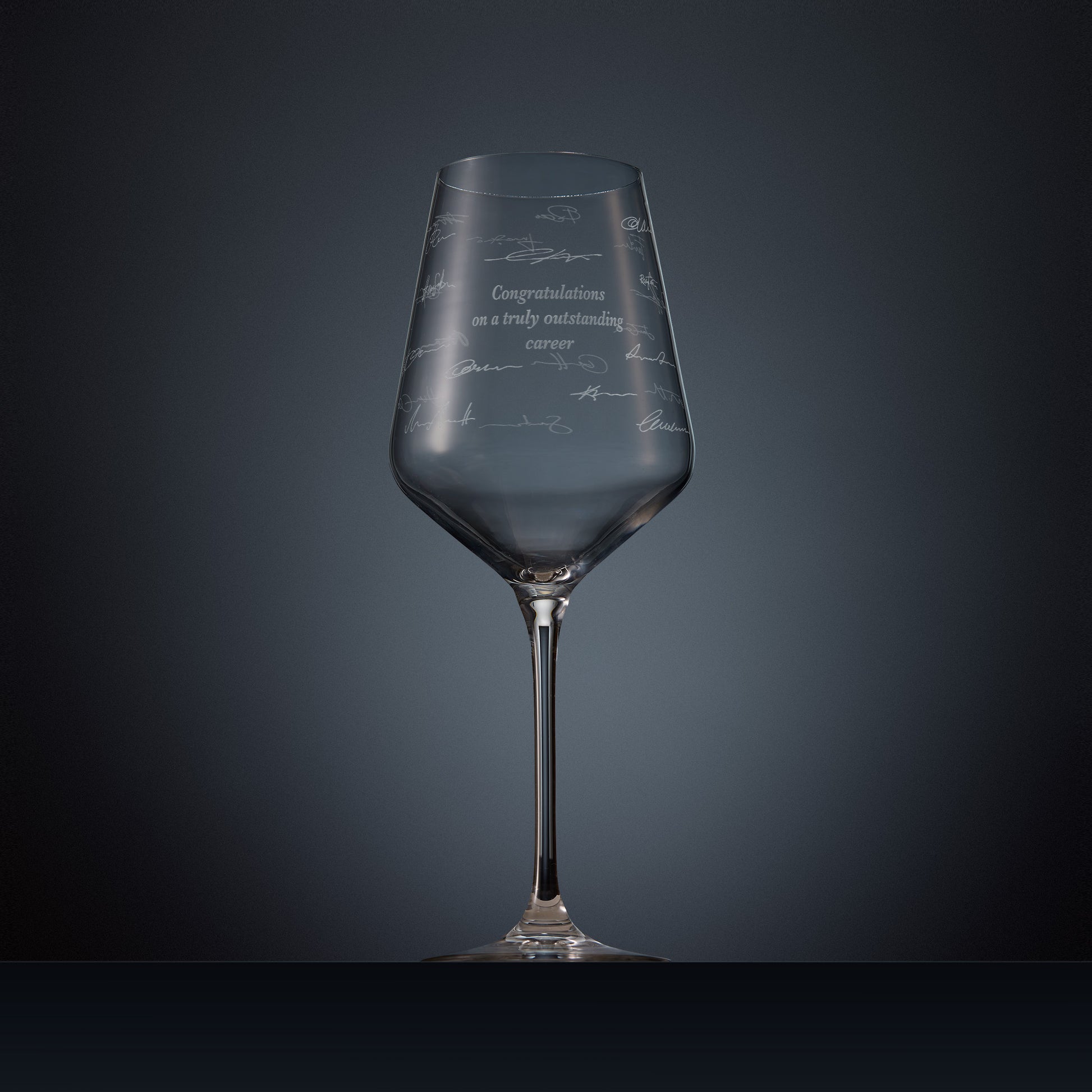Engraved wine glass with congratulations text and handwritten signatures in a wraparound design