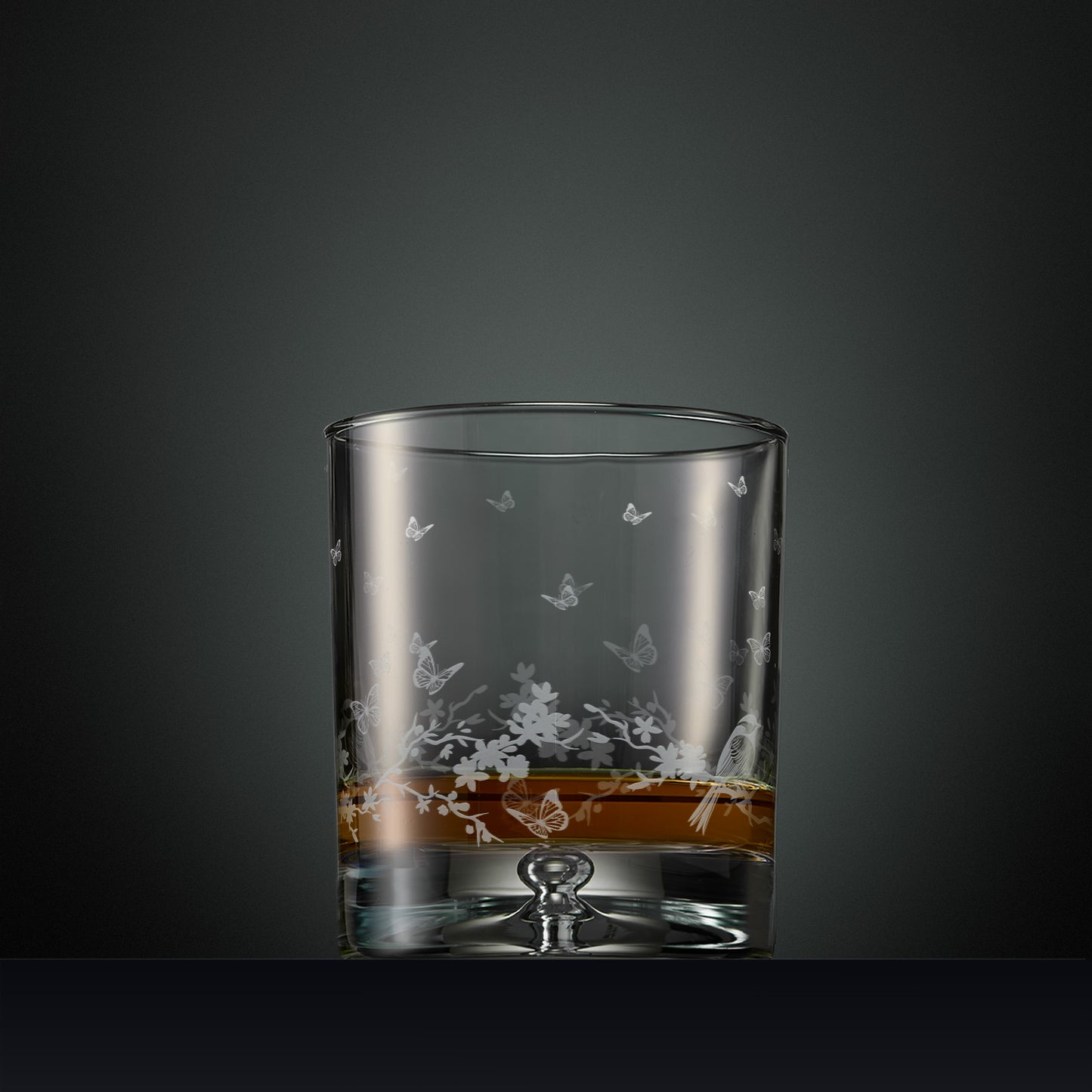 Engraved wraparound garland featuring garden birds and butterflies on a whisky glass