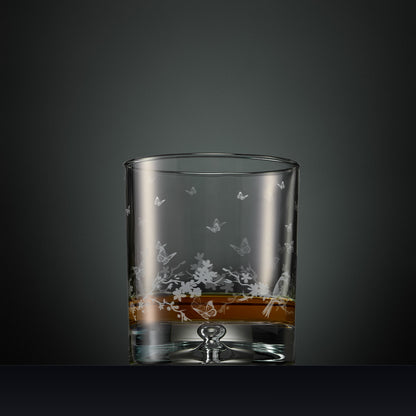 Engraved wraparound garland featuring garden birds and butterflies on a whisky glass
