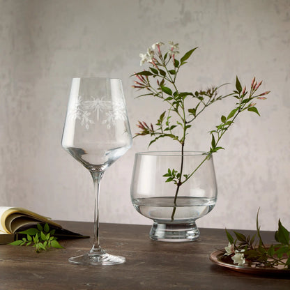 Engraved wine glass featuring a dragonfly, honeysuckle and roses in a wraparound composition