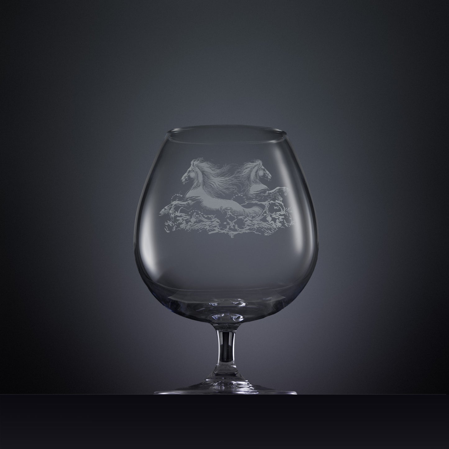 Engraved brandy glass with an  illustration of two horses galloping through the water
