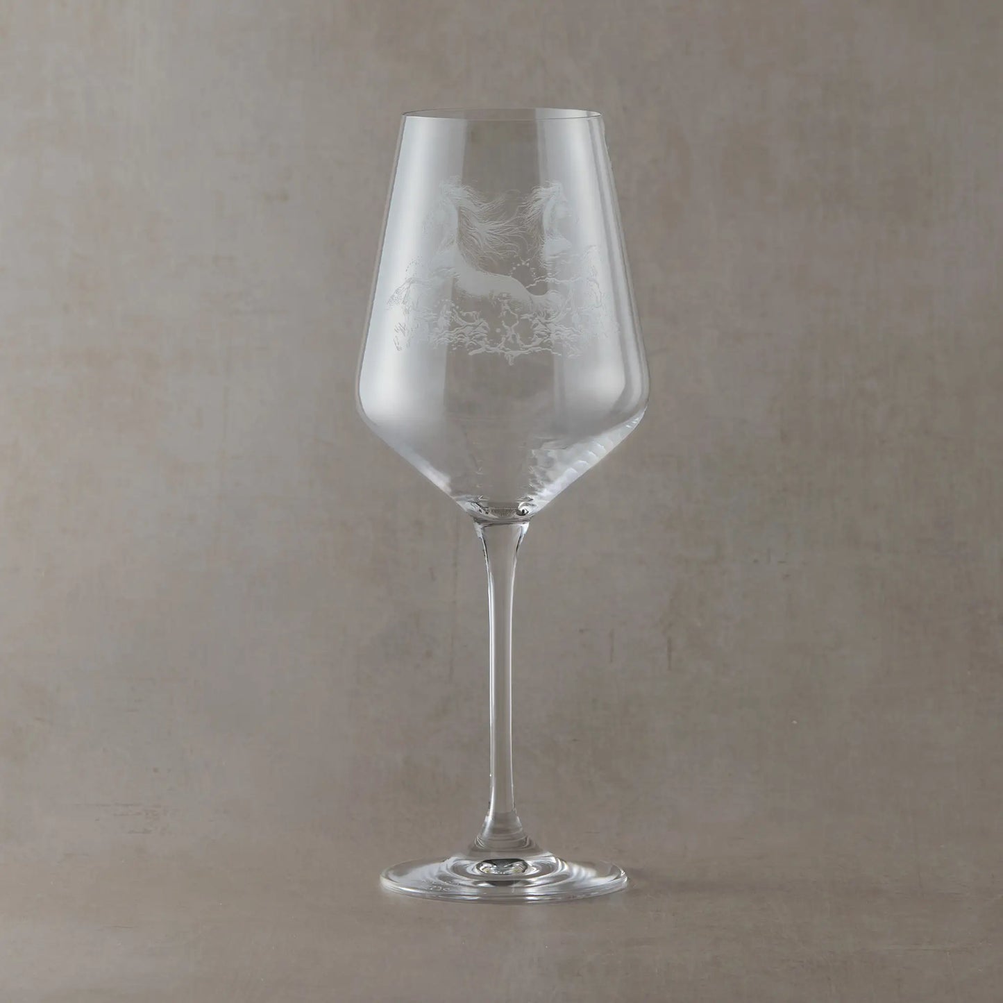 Engraved wine glass with an  illustration of two kelpies galloping