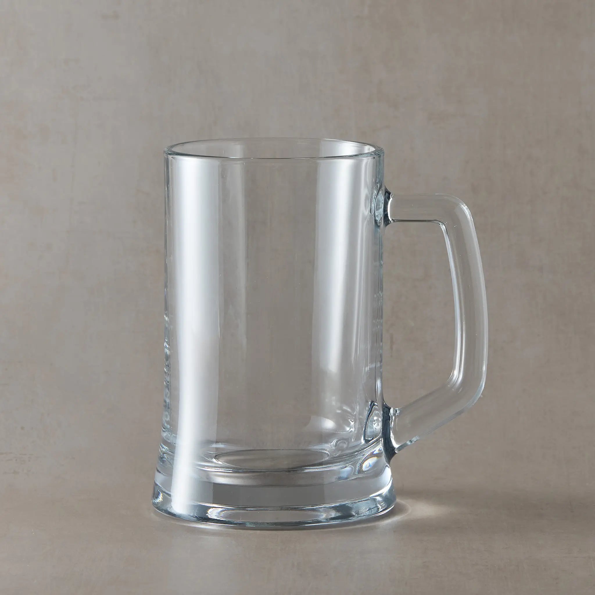 A clear glass tankard with a thick handle and a sturdy base.