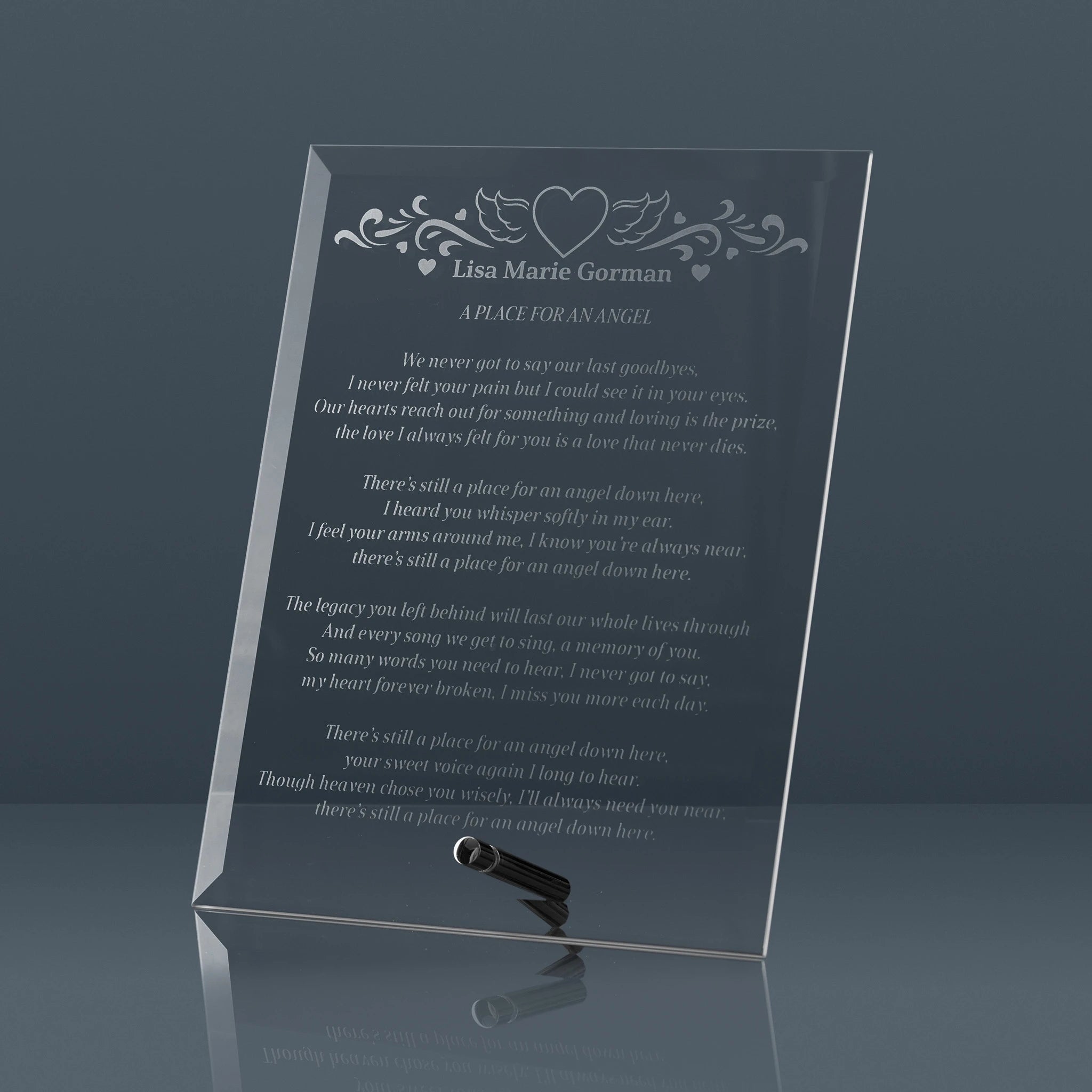 Memorial plaque with engraved text and a heart design on a dark background