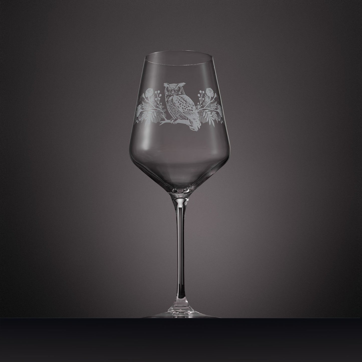 Engraved wine glass featuring marigolds, cosmos and a tawny owl