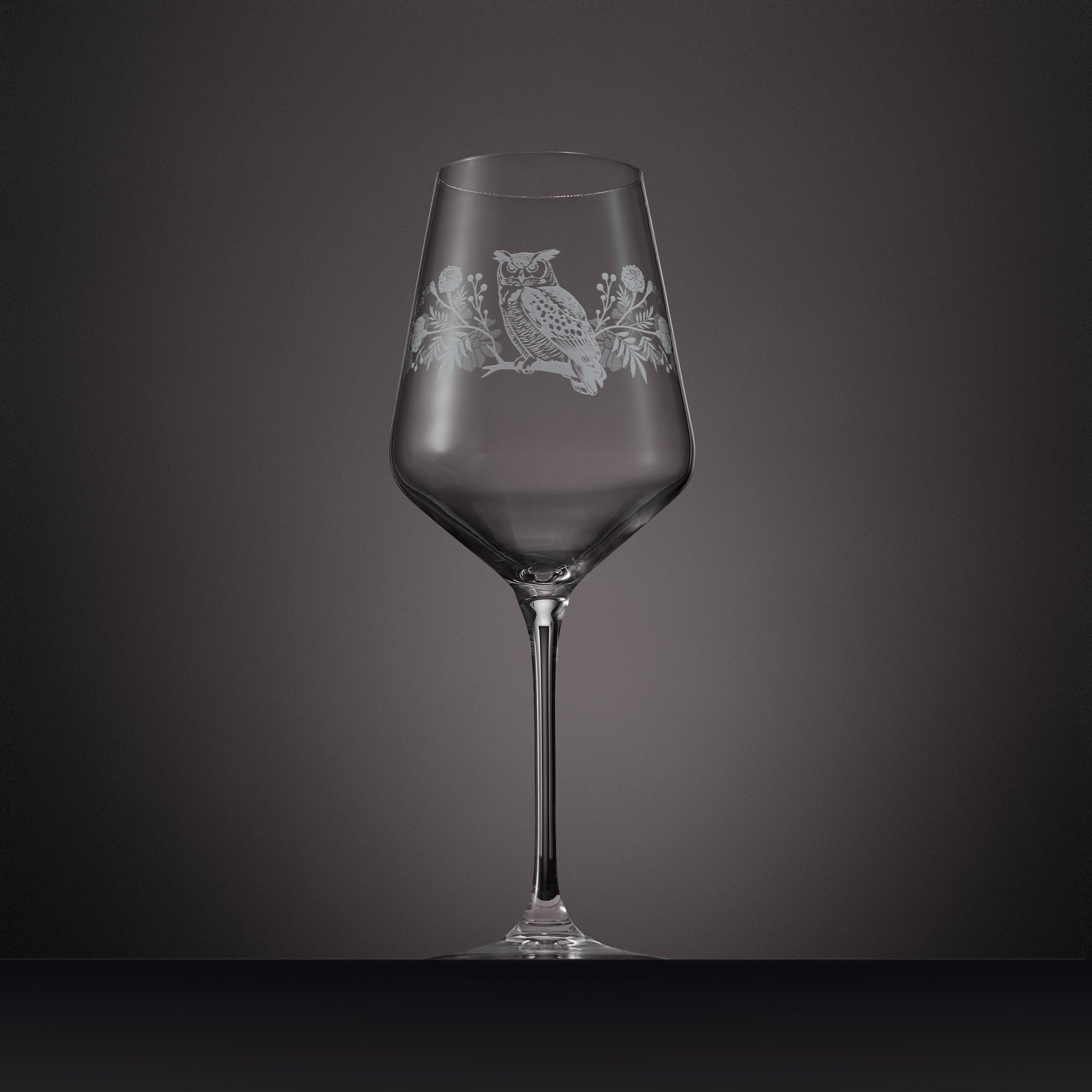 Engraved wine glass featuring marigolds, cosmos and a tawny owl