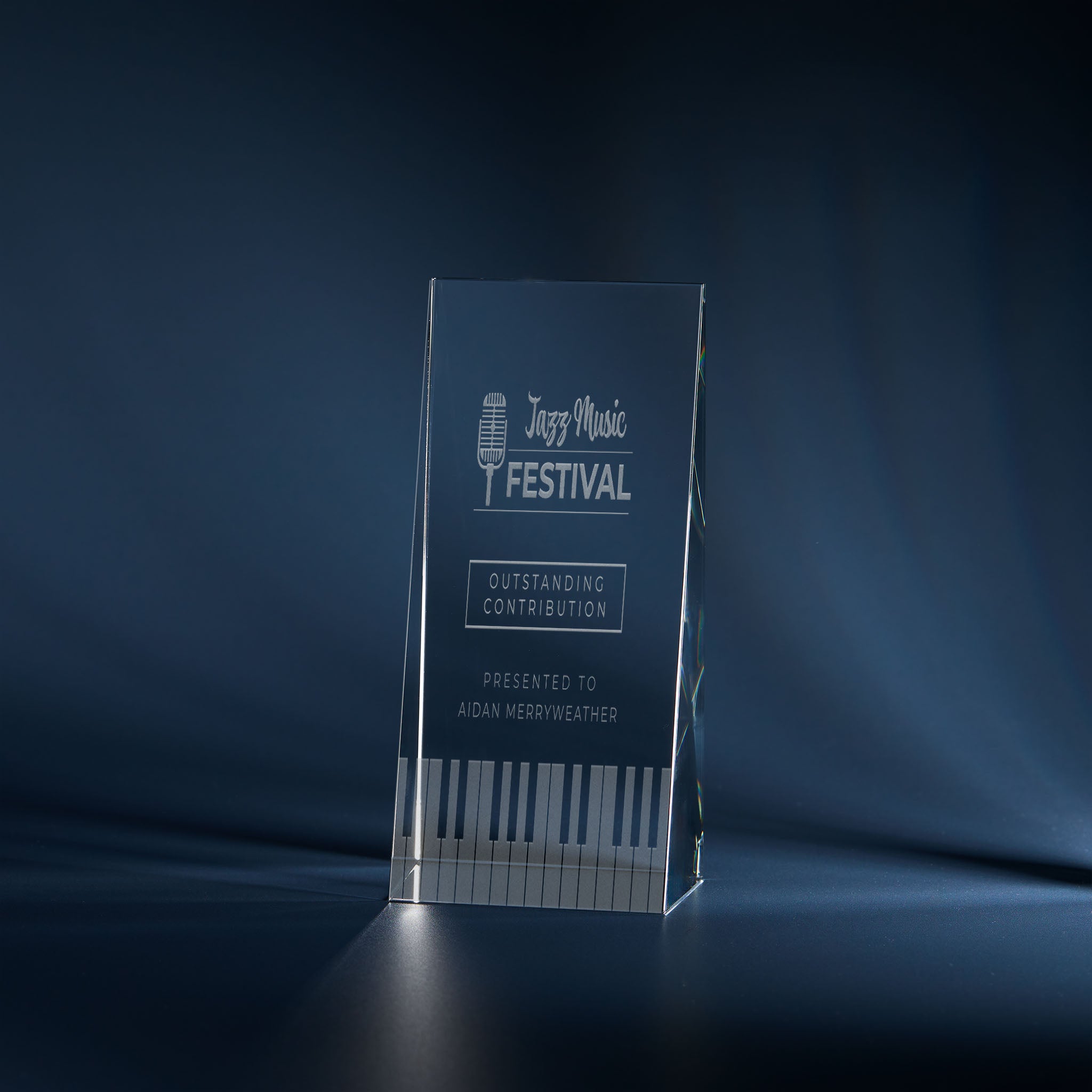 Engraved optical crystal wedge award with music-themed design and personalised inscription