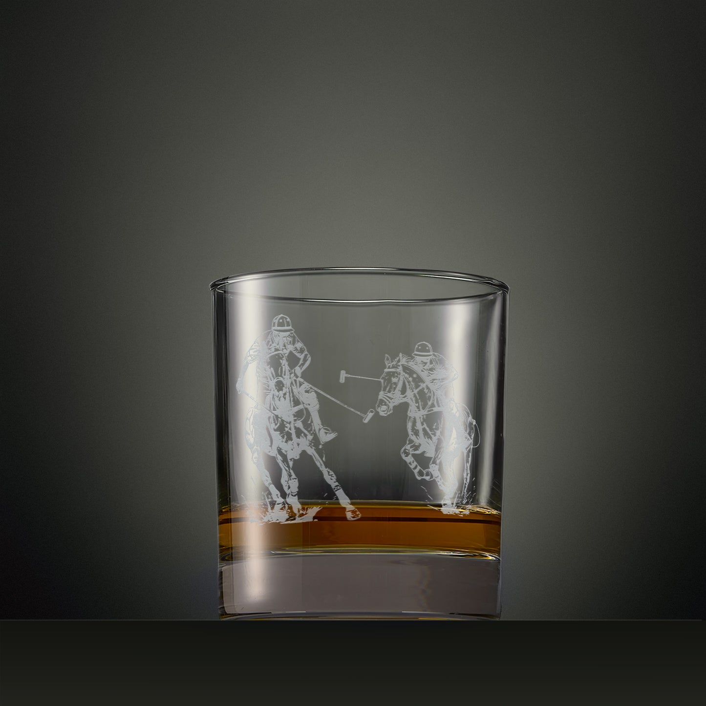 Engraved whisky glass featuring two polo players in action with crossed mallets.