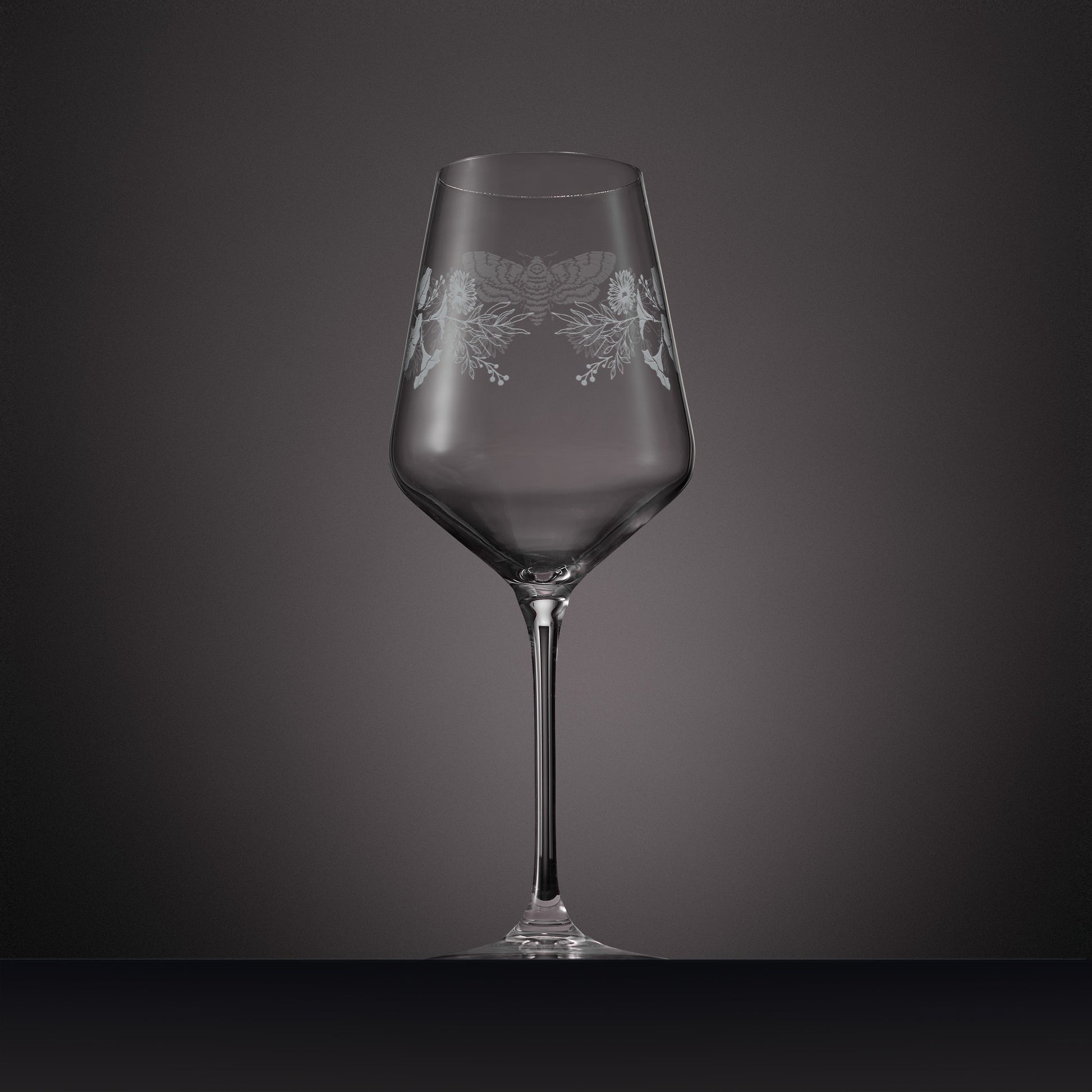 Wraparound engraving of asters, morning glory and a moth on a wine glass
