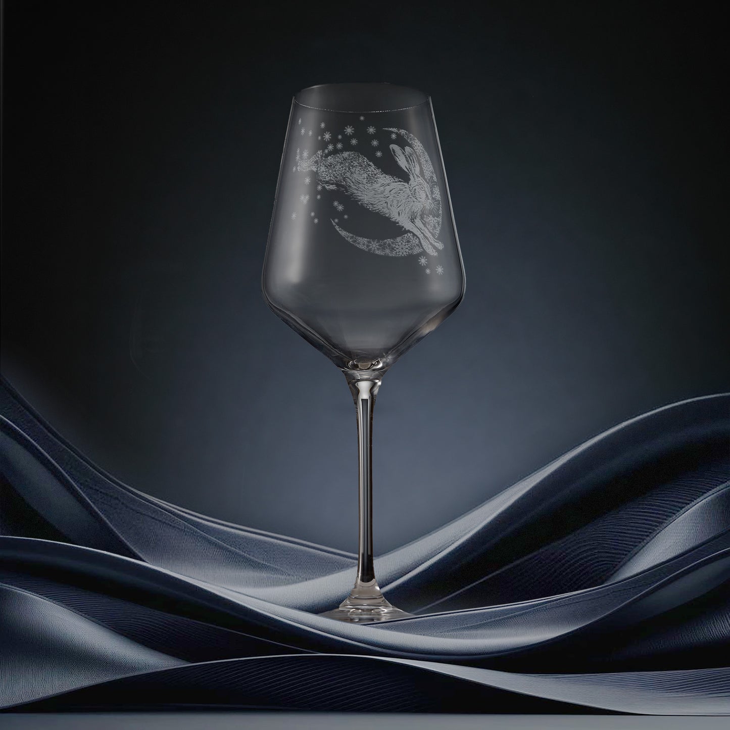 Engraved wine glass featuring a hare leaping across a crescent moon of snowflakes