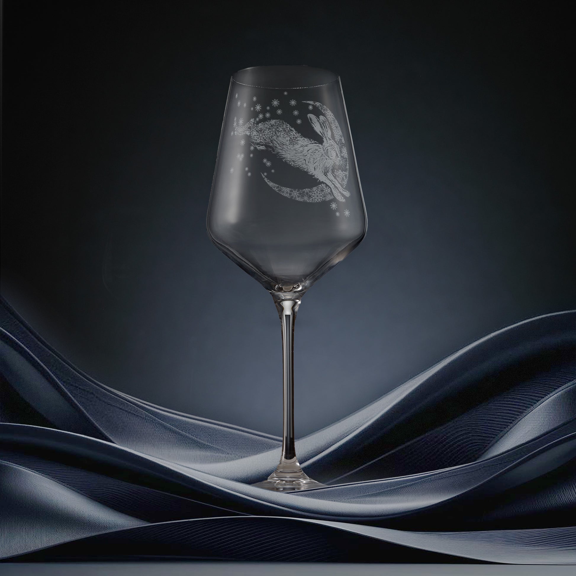 Engraved wine glass featuring a hare leaping across a crescent moon of snowflakes